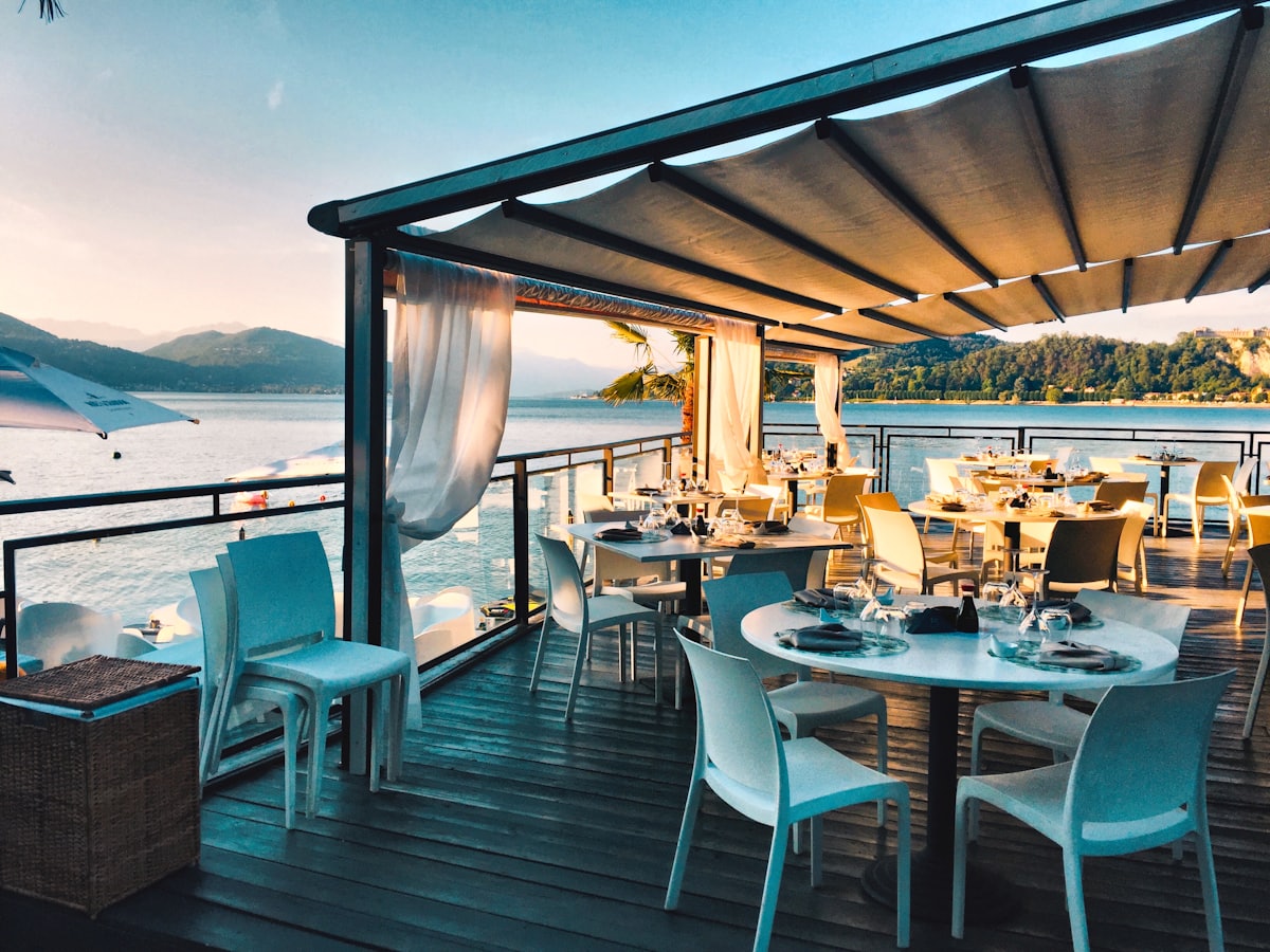 Waterside restaurant terrace set for service at golden hour